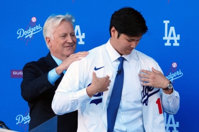 Dodgers owner Mark Walter puts a jersey on Shohei Ohtani during the superstar's introductory news conference on Thursday. The structure of Ohtani's contract could help the Dodgers get a full return on their investment in the two-way player.