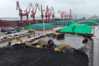 Diggers move piles of coal after it was unloaded from a ship at Lianyungang Port in China's Jiangsu province.  | AFP-JIJI