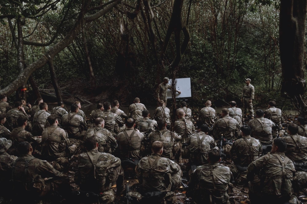 A group of 79 soldiers at the U.S. Army’s jungle training school prepare to enter a river on the Hawaiian island of Oahu on Nov. 29. Far from the deserts of the Middle East, the Army is instructing troops in Hawaii on the skills needed for a potential clash with China. 