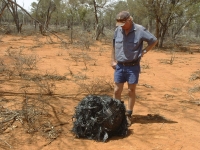 An Australian farmer stands next to a ball of twisted metal, purported to be fallen space junk. | Reuters