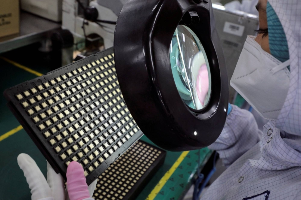 A worker inspects semiconductor chips at a chip-packaging plant in Ipoh, Malaysia, in 2021. Malaysia currently accounts for 13% of the global market for semiconductor packaging, assembly and testing.