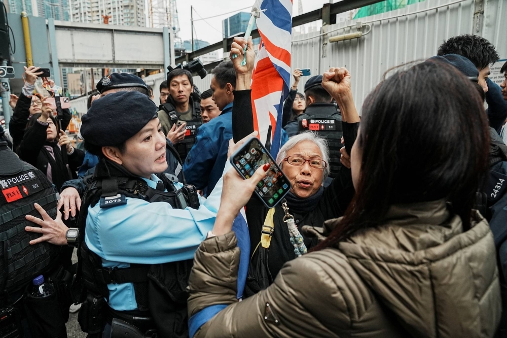 A security personnel stops a supporter during the national security trial of media mogul Jimmy Lai in Hong Kong on Monday.