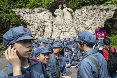 Children dressed as Chinese Red Army soldiers in front of a statue of Mao Zedong at the Revolution Museum in Jinggangshan, China, in 2021
