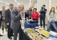 Rahm Emanuel, U.S. ambassador to Japan, eats scallops from Hokkaido at Yokota Air Base in Tokyo. | KYODO