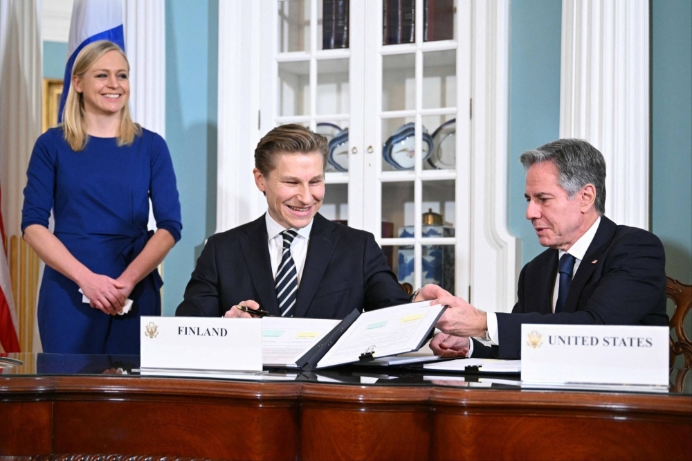U.S. Secretary of State Antony Blinken (right), Finland's Foreign Minister Elina Valtonen (left) and Finland's Defense Minister Antti Hakkanen sign a defense cooperation agreement in the Treaty Room of the U.S. State Department in Washington on Dec. 18.