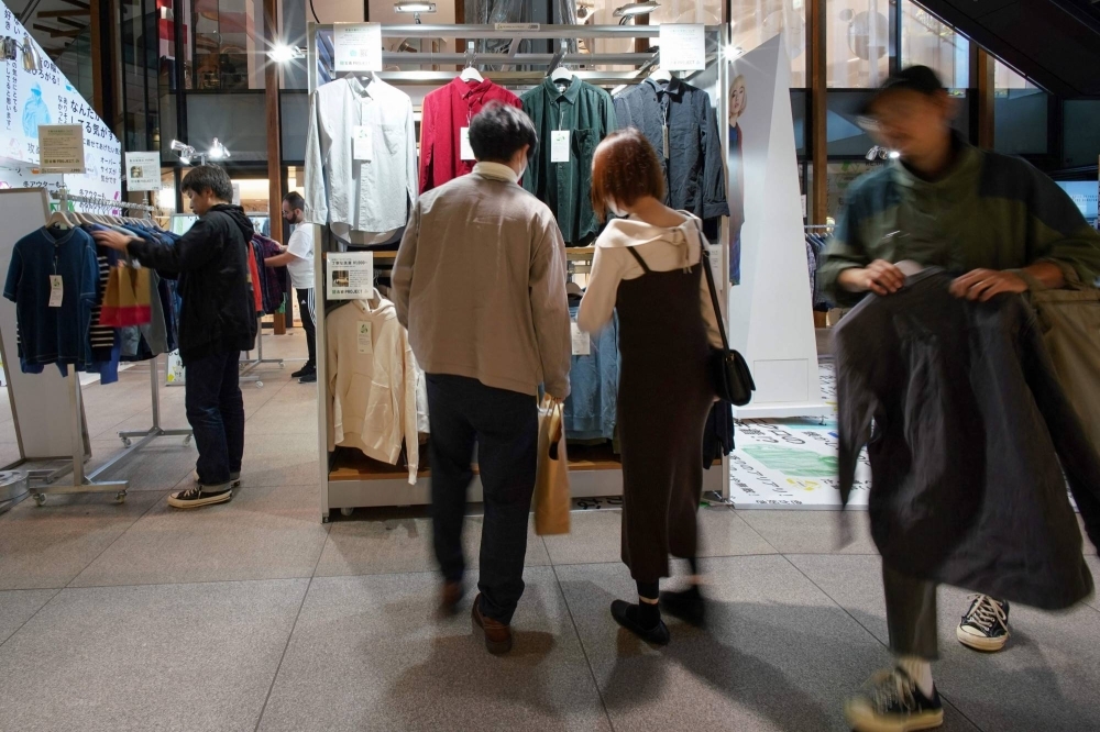 Customers browse through items sold as part of the Uniqlo Pre-owned Clothes Project at the brand's Harajuku store in Tokyo in October. 