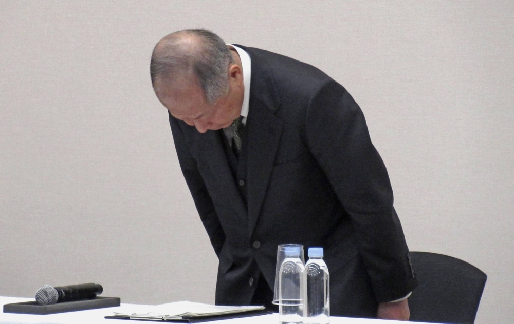 Seiichiro Nishioka, an outside director, apologizes at a news conference on Tuesday.