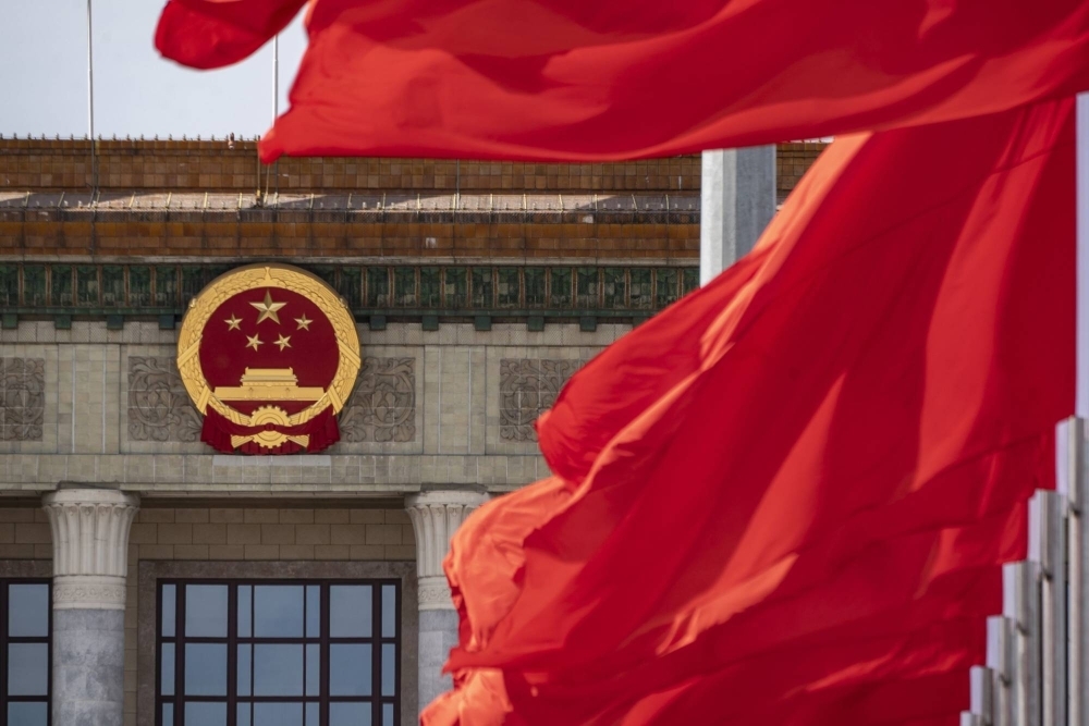The Chinese national emblem and flags at the Great Hall of the People in Beijing on Oct. 18.