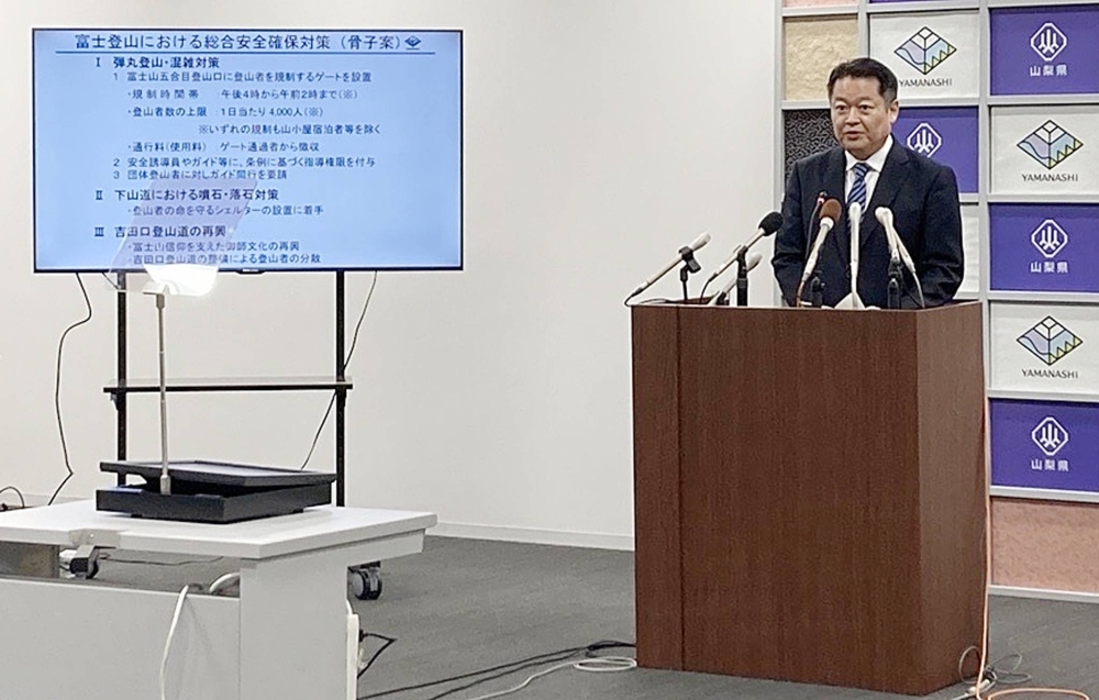 Yamanashi Gov. Kotaro Nagasaki speaks at a news conference at the prefectural government office on Wednesday. The prefecture is set to begin charging people to climb Mount Fuji.