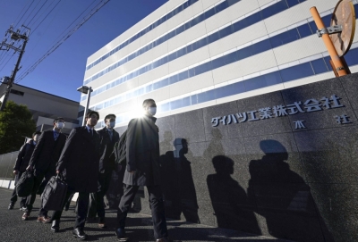 Officials from the transport ministry enter Daihatsu Motor's headquarters in Ikeda, Osaka Prefecture, on Thursday for inspection after a scandal regarding safety data manipulation emerged at the firm.