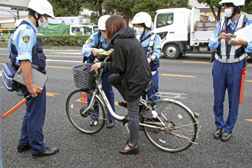 Police officers explain bicycle rules during an event in Tokyo last year.