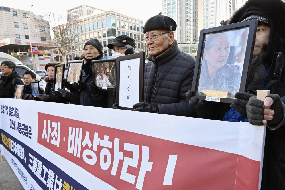 Families of deceased plaintiffs in lawsuits over wartime labor during Japan's colonial rule outside South Korea's Supreme Court in Seoul on Thursday