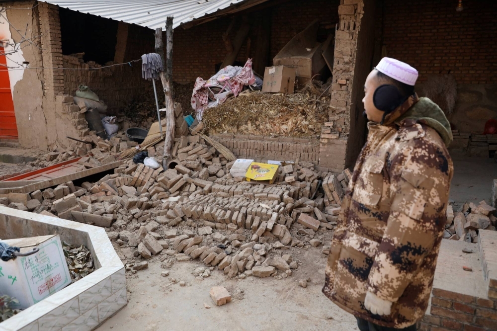 A man in front of his damaged house on Wednesday following an earthquake in China's Gansu province