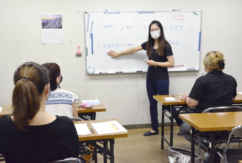 A Brazilian of Japanese descent teaches Japanese to foreign nationals in July 2020 at the Homi housing complex in Toyota, Aichi Prefecture, which is home to many foreign nationals, mainly of Brazilian heritage.
