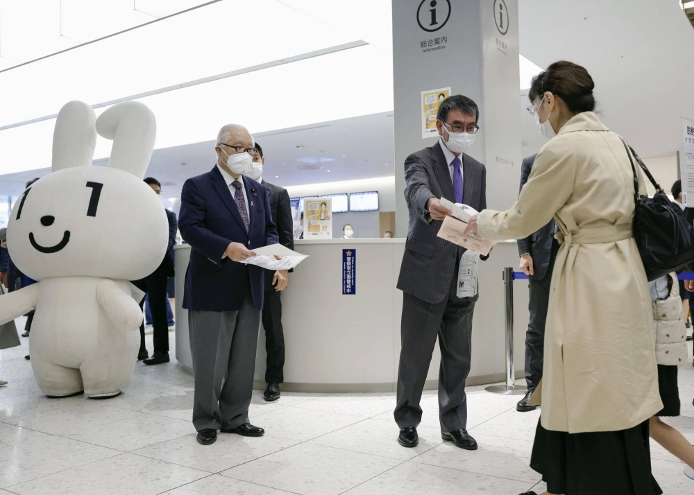 Digital minister Taro Kono (second from right) and health minister Keizo Takemi hand out leaflets to promote the use of My Number cards as health insurance certificates at Jikei University Hospital in Tokyo last month.