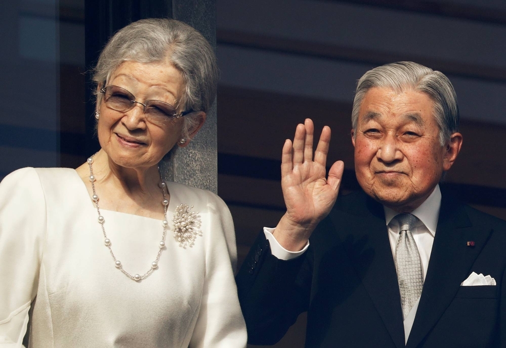 Empress Emerita Michiko and Emperor Emeritus Akihito wave to well-wishers at the Imperial Palace in Tokyo in 2020. 