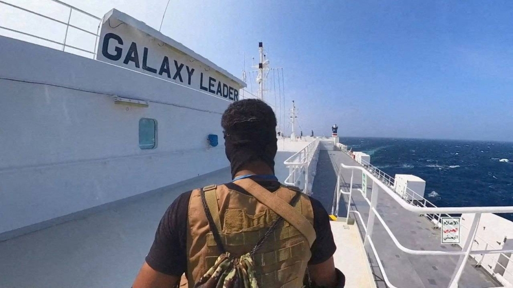 A Houthi fighter stands on the Galaxy Leader cargo ship in the Red Sea in a photo released Nov. 20. 