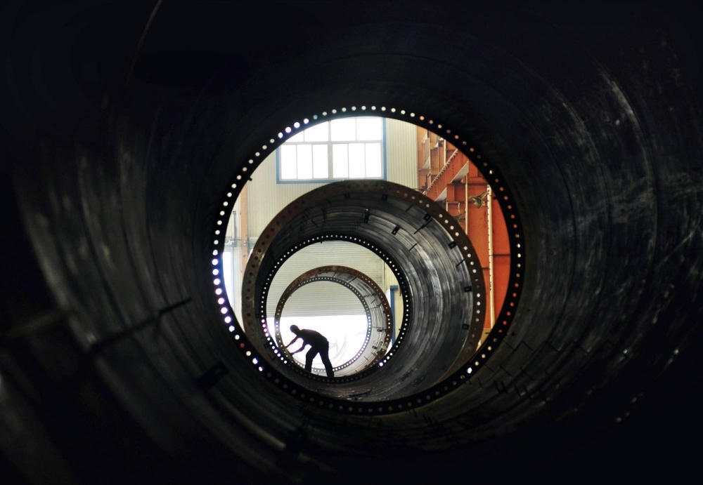 A worker builds the components of wind turbines at a factory in Zouping, China. A worker builds the components of wind turbines at a factory in Zouping, China.