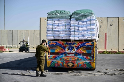 A member of the Israeli security forces inspects humanitarian aid trucks arriving from Egypt on the Israeli side of the Kerem Shalom border crossing with the southern Gaza Strip on Friday.