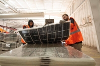 Workers push damaged solar panels into a machine to be recycled at the We Recycle Solar plant in Yuma, Arizona. | AFP-Jiji