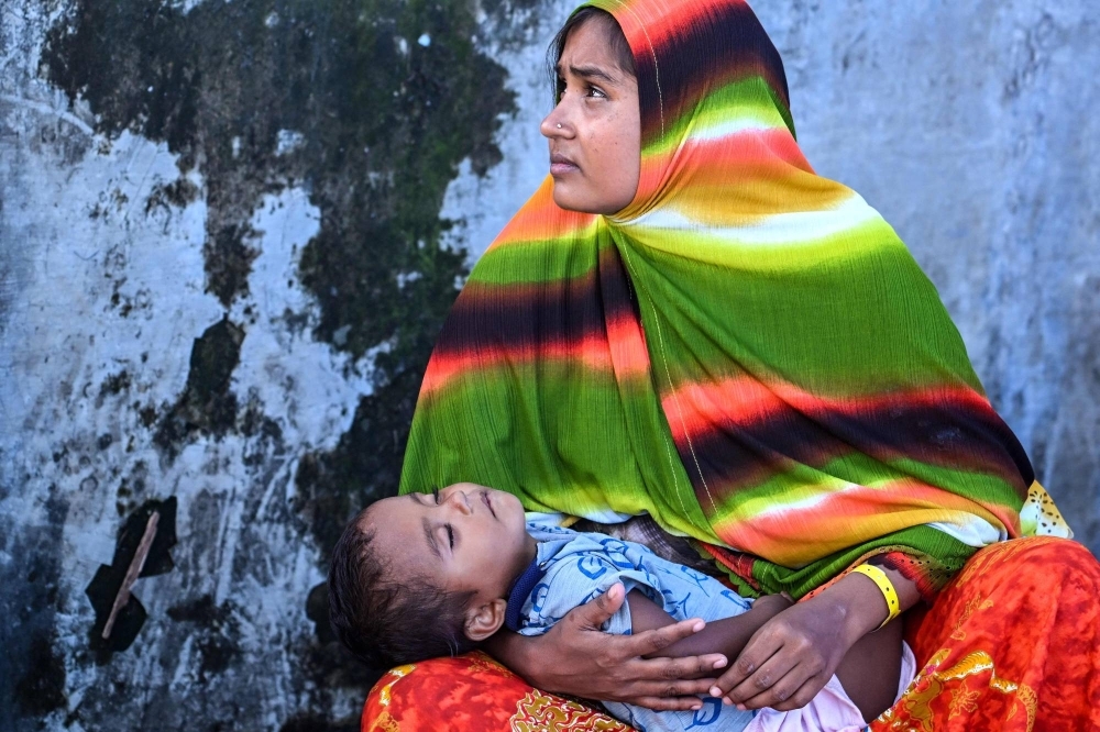 A Rohingya refugee woman holds her child at a temporary camp, at a port on Sabang island in Indonesia's Aceh province.
