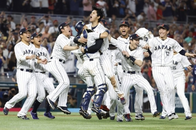 Designated hitter and closer Shohei Ohtani (center) and catcher Yuhei Nakamura are mobbed by their Samurai Japan teammates after Ohtani struck out American slugger Mike Trout to clinch Japan’s third World Baseball Classic and first since 2009, at LoanDepot Park in Miami on March 21.