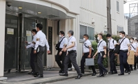 Tokyo police raid the dormitory of the Nihon University football team in the capital’s Nakano Ward on Aug. 3. Several players from the team were involved in a drug scandal, leading to the storied club’s disbandment later in the year. | Jiji
