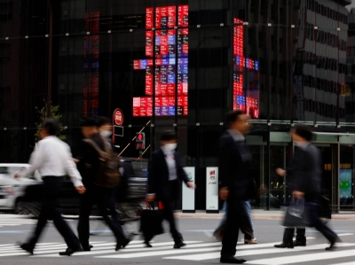 An electronic board displays various companies' share prices at a business district in Tokyo in October.