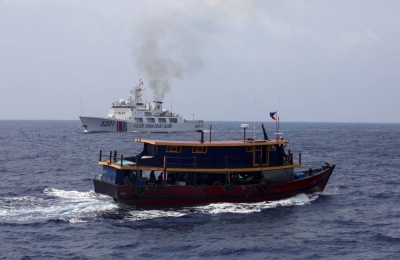 A Philippine supply boat sails near a Chinese Coast Guard ship during a resupply mission for Filipino troops stationed at a grounded warship in the South China Sea on Oct. 4.