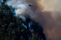 A helicopter waterbombs fires near Port Alberni, British Columbia, on June 6. Record wildfires devastated huge swaths of forest in Canada, with scientists saying the disasters were made worse by climate change. | Bloomberg 