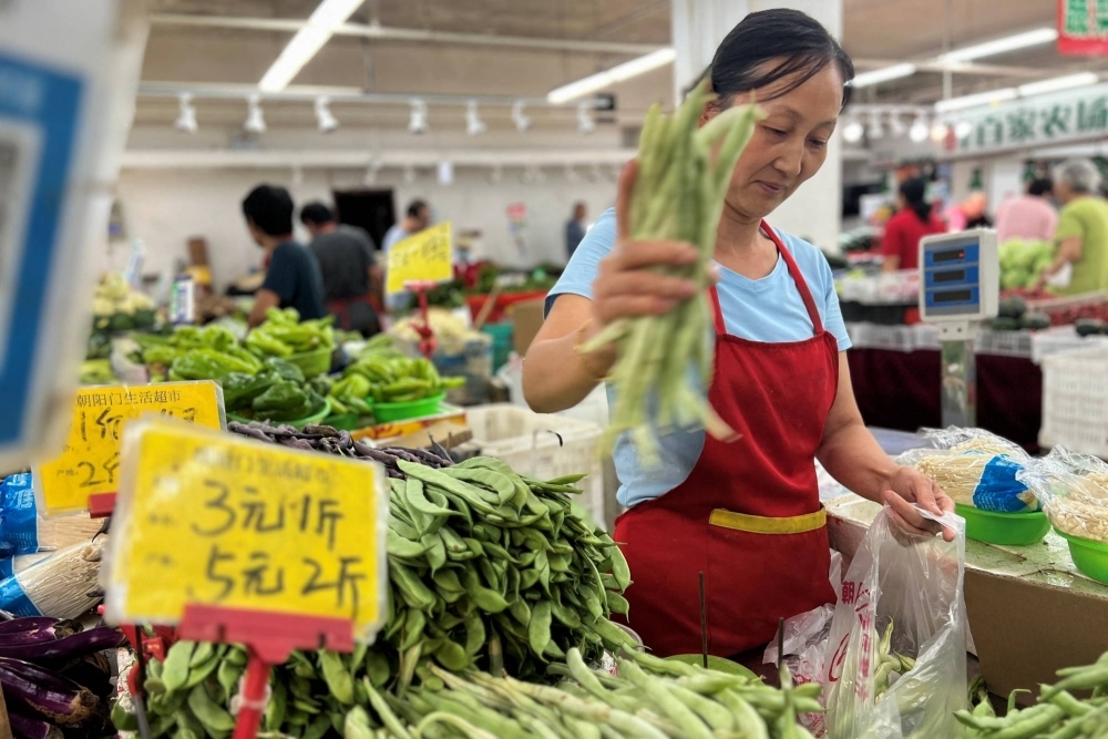A vegetable vendor at a wet market in Beijing on Aug. 10. The Chinese economy was in focus throughout the year, with a lingering real estate downturn, a difficult geopolitical environment and a slow recovery from the COVID-19 pandemic all weighing on the world’s No. 2 economy.