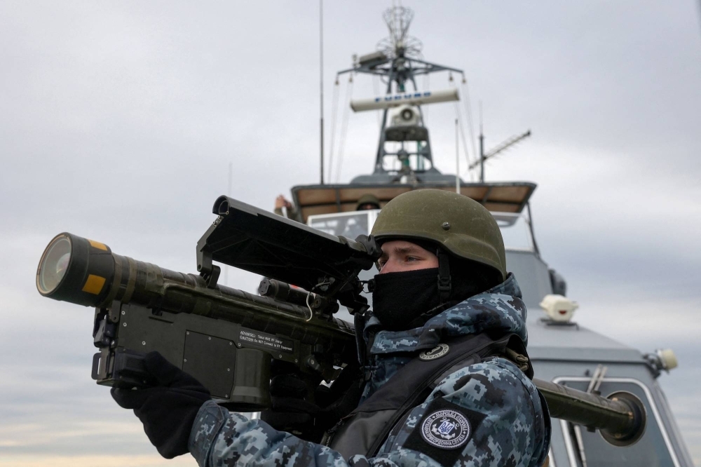 A Ukrainian serviceman holds a anti-aircraft weapon as they scan for possible air targets, onboard a boat as it patrols the northwestern part of the Black Sea.
