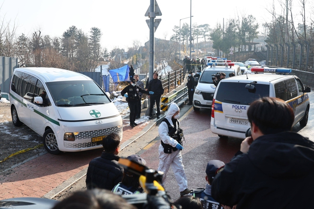 An ambulance (left) carrying the body of South Korean actor Lee Sun-kyun leaves a park in central Seoul on Wednesday. Lee, best known for his role in the Oscar-winning film "Parasite," was found dead in an apparent suicide, Yonhap news agency reported.