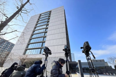 Reporters gather in front of the Upper House parliamentary building on Thursday in Tokyo. Prosecutors raided LDP lawmaker Yasutada Ono's office, which is located in the building, the same day.