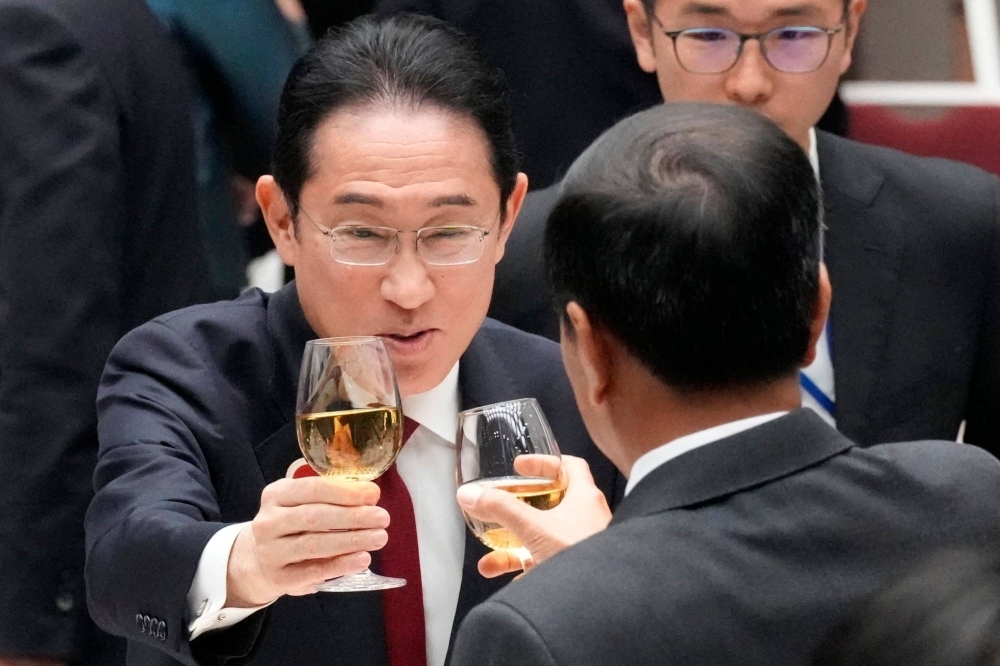 Prime Minister Fumio Kishida makes a toast with Indonesian President Joko Widodo at a Japan-ASEAN luncheon meeting at the Japan Business Federation in Tokyo on Dec. 18. Kishida’s chance of reelection in the LDP presidential race in September will largely depend on his administration’s response to the current funding scandal and its entanglement in it.