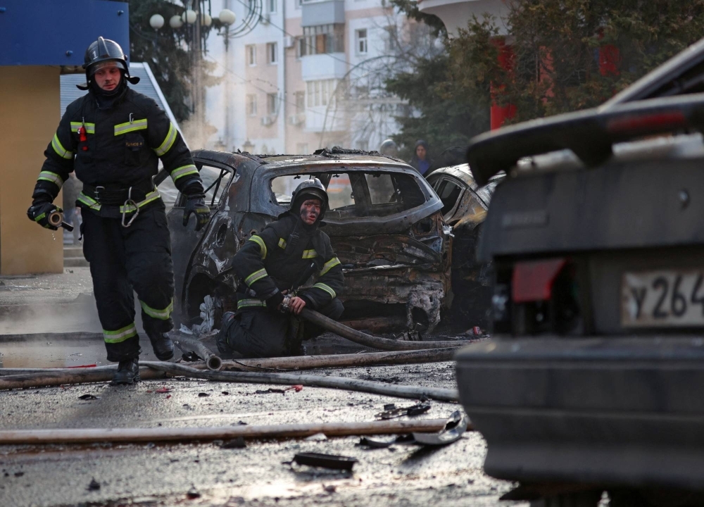 Firefighters work to extinguish burning cars following what Russian authorities say was a Ukrainian military strike in Belgorod, Russia, on Saturday. 