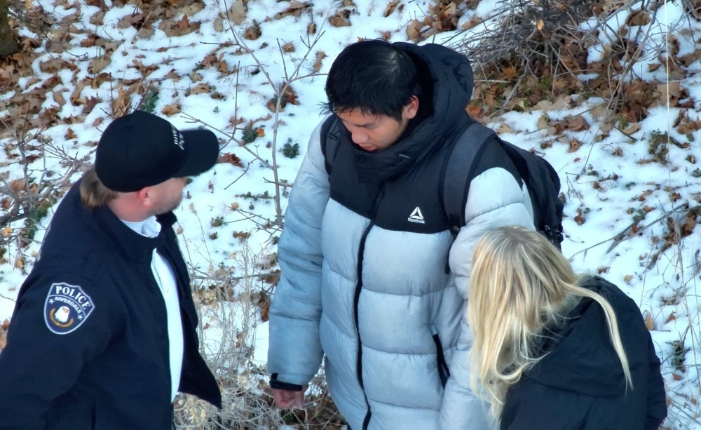U.S. police speak to a Chinese exchange student near the site where he was found in the mountains near Brigham City, Utah, on Sunday after being reported missing. 