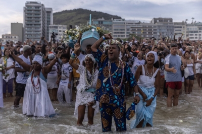 Devotees of Afro-Brazilian religions carry offerings to the sea as part of an annual rite in Rio de Janeiro on Dec. 29, 2023.