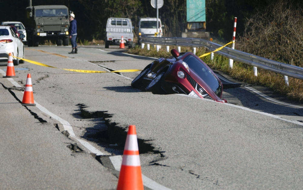 A vehicle in a collapsed portion of a road in Anamizu, Ishikawa Prefecture, on Tuesday 