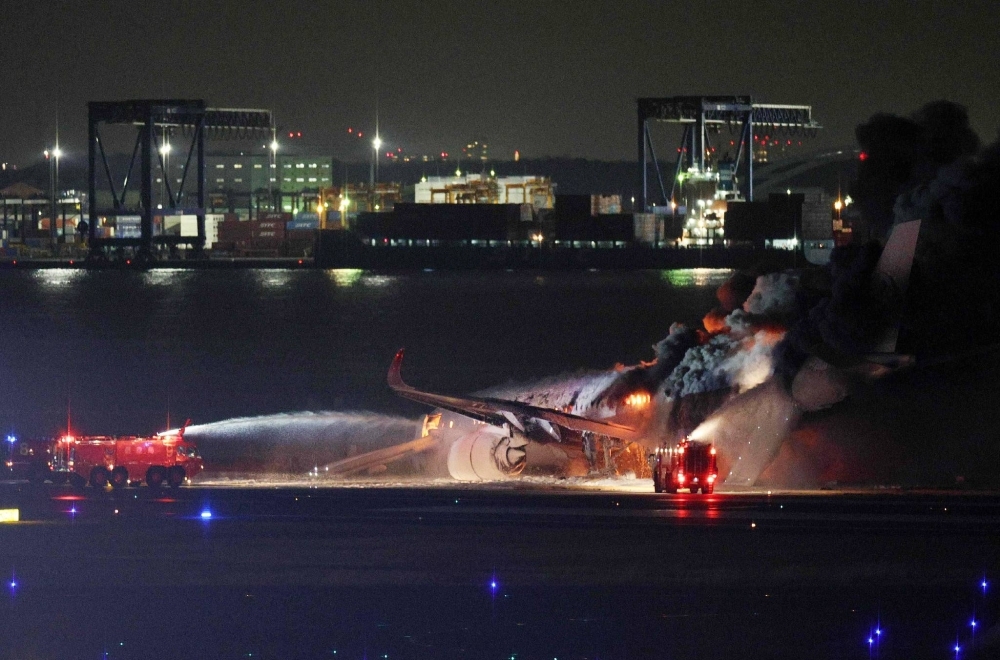The burning Japan Airlines plane at Haneda Airport on Tuesday 
