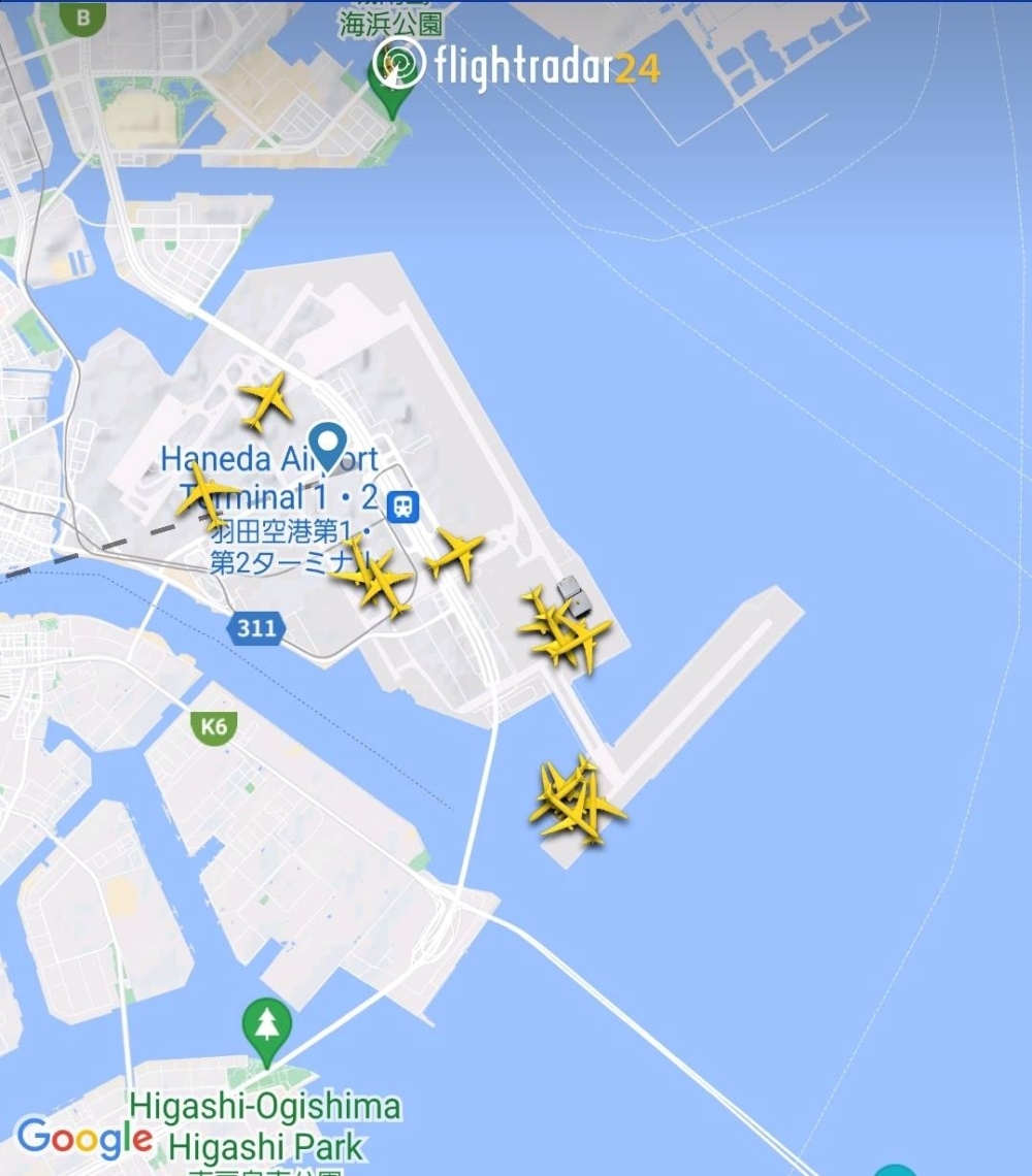 A screenshot from the Flightradar24 app at 7:25 p.m. Tuesday shows planes waiting on runways at Haneda Airport after all of the major transport hub's runways were closed following an apparent collision between a Japan Airlines jet and a Japan Coast Guard plane. 