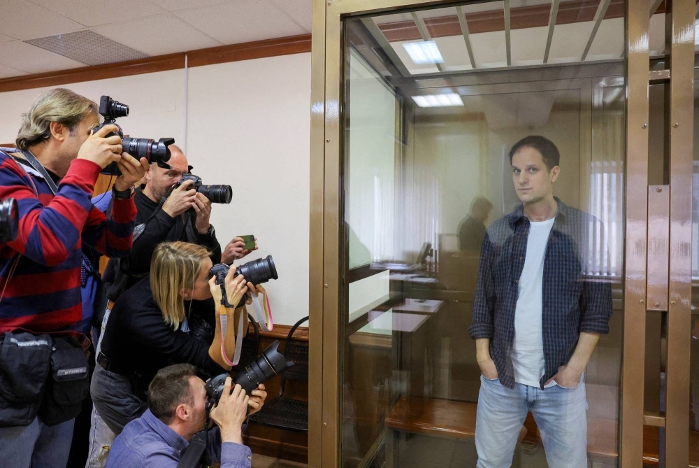 Wall Street Journal reporter Evan Gershkovich stands inside an enclosure for defendants during a court hearing on espionage charges in Moscow on Oct. 10.