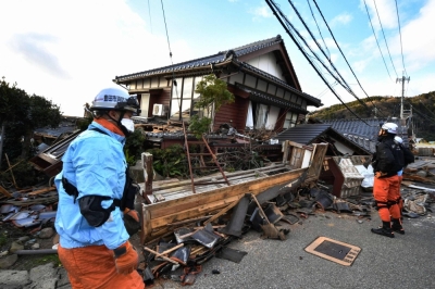 Firefighters inspect earthquake-damaged houses in Wajima, Ishikawa Prefecture, on Tuesday.