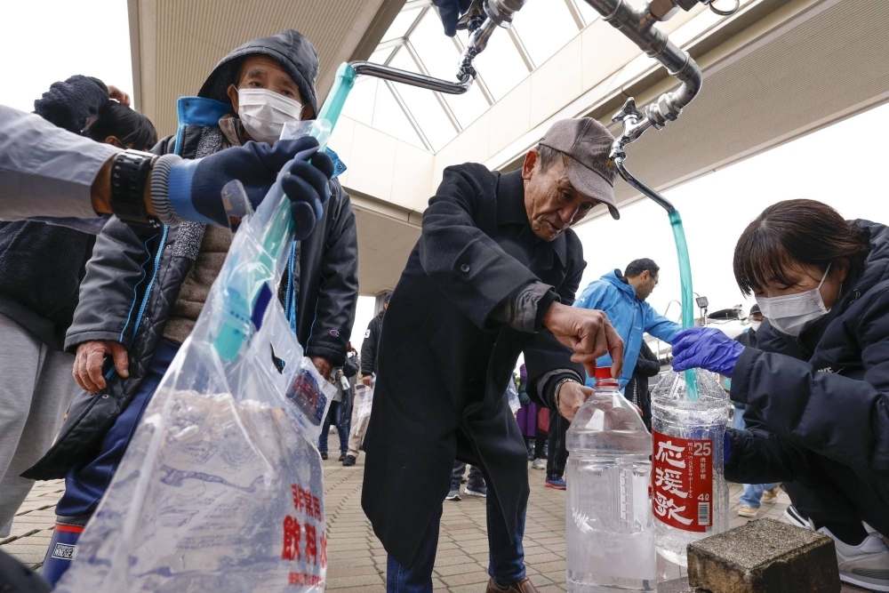 People receive a supply of water in Shika, Ishikawa Prefecture.