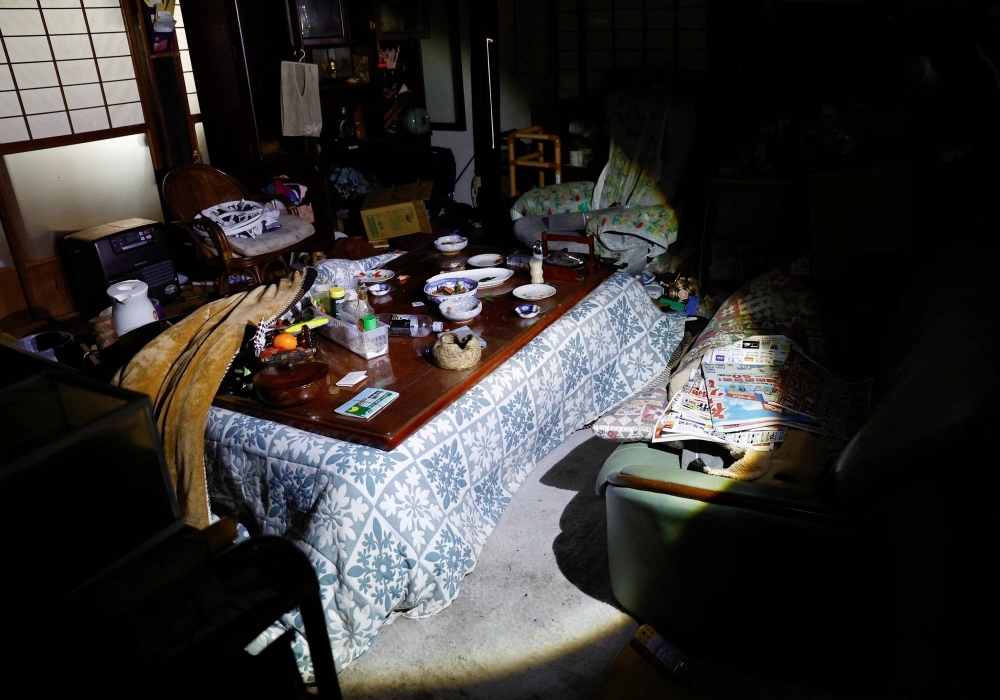 Shoichi Kobayashi shows a dinner table, with a lantern light, on which he had his New Year's dinner when an earthquake hit his house in Wajima, Ishikawa Prefecture.