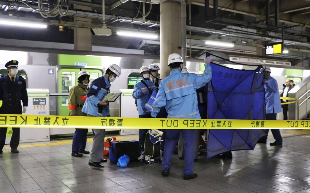 Emergency crew tend to an injured passenger on a Yamanote line platform at JR Akihabara Station on Wednesday night.