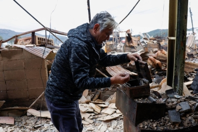 A man inspects what remains of his liquor shop which was burnt down by a fire, in the aftermath of an earthquake, in Wajima, Ishikawa Prefecture, on Thursday.