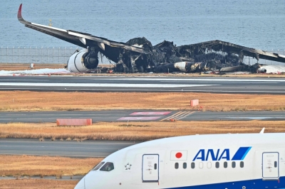 The burned wreckage of a Japan Airlines passenger plane lies on the tarmac at Tokyo’s Haneda Airport on Wednesday. AFP-JIJI