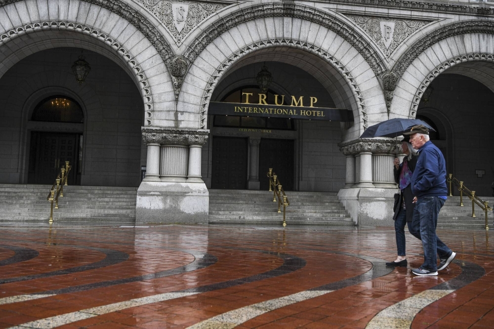 Pedestrians walk past the Trump International Hotel in Washington. House Democrats have released evidence that the former president took in at least $7.8 million from foreign entities while in office, engaging in the kind of conduct House Republicans are grasping to pin on U.S. President Joe Biden.