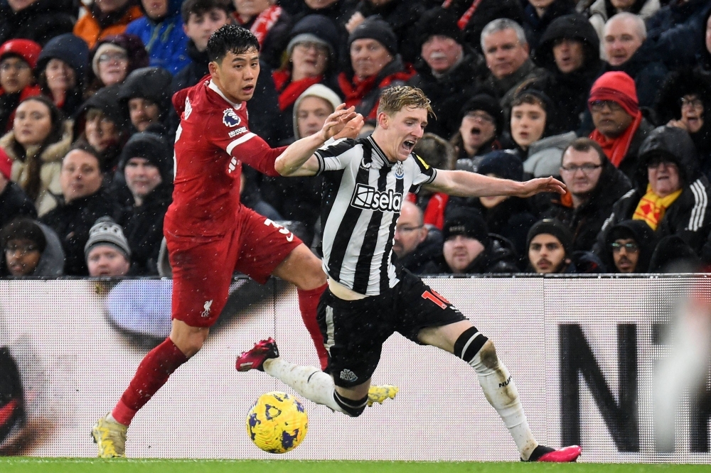 Liverpool midfielder Wataru Endo views with Newcastle United's Anthony Gordon during a match on Monday. 